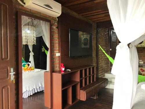 a room with a bedroom with a bed and a television at Pousada Alto Astral in Olinda