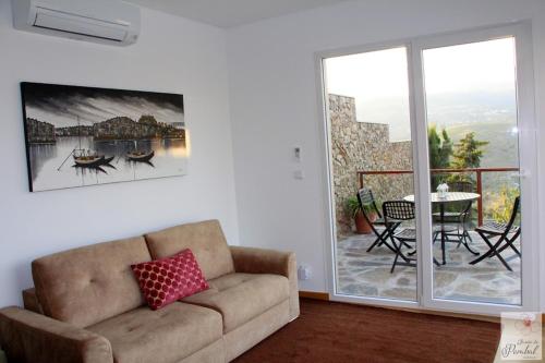 un soggiorno con divano e tavolo e un balcone di Quinta do Pombal - Douro - Camila's a Lamego