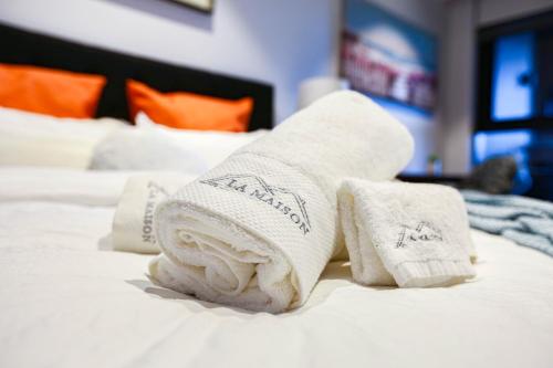 a pile of towels sitting on top of a bed at Box Hill Central Sky One Apartment in Box Hill