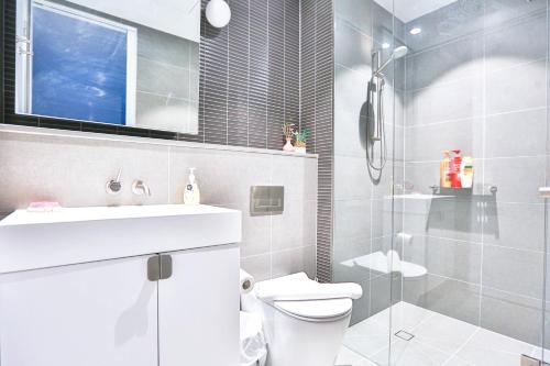 a bathroom with a toilet and a sink and a shower at Box Hill Central Sky One Apartment in Box Hill