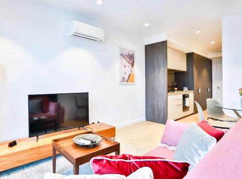 a living room with a couch and a table at Box Hill Central Sky One Apartment in Box Hill