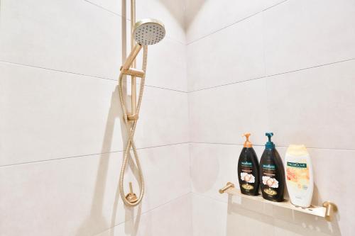 a shower with a shower head and two bottles at Box Hill Central Sky One Apartment in Box Hill