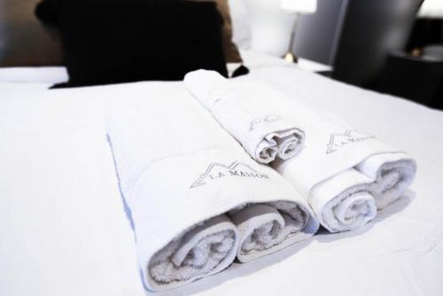 a pile of towels sitting on top of a bed at Box Hill Central Sky One Apartment in Box Hill
