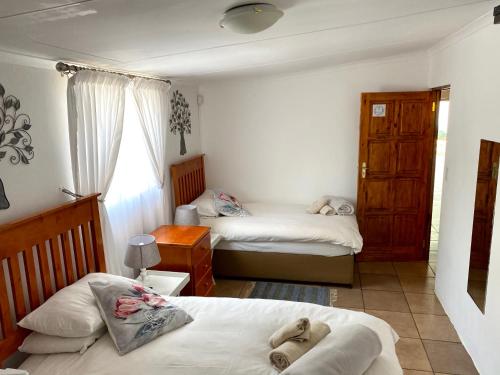 a small bedroom with two beds and a window at La Bella B&B Under The Fig Tree in Bela-Bela