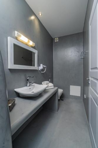 a bathroom with a sink and a toilet at Central Fira Suites in Fira