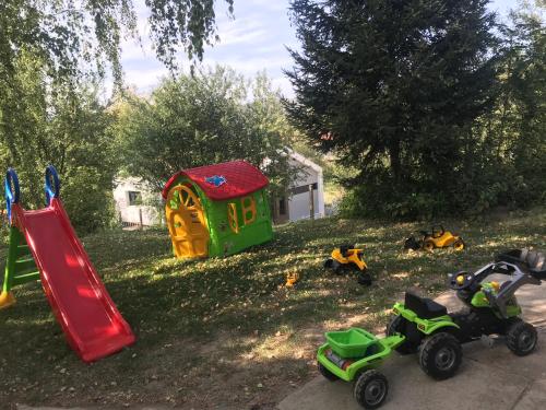 un grupo de juguetes en la hierba con un parque infantil en Vikend kuća Betula en Vrdnik