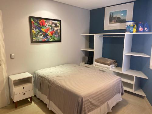 a bedroom with a bed in a room with shelves at Casa de Campo Alto Padrao in Piracaia