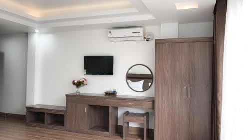 a room with a table and a mirror and a tv at Wind House Hotel in Sa Pa
