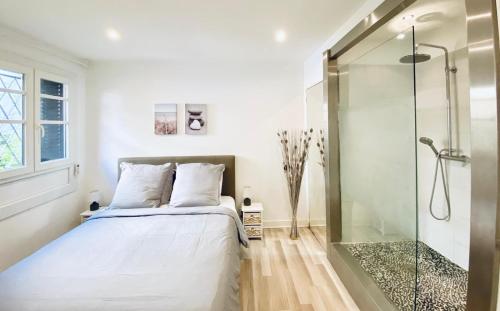 een slaapkamer met een bed en een glazen douche bij CAUVI - Antibes Centre, WIFI, Climatisation, 4 personnes in Antibes
