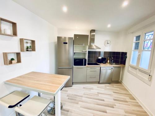 een keuken met een houten tafel en roestvrijstalen apparatuur bij CAUVI - Antibes Centre, WIFI, Climatisation, 4 personnes in Antibes