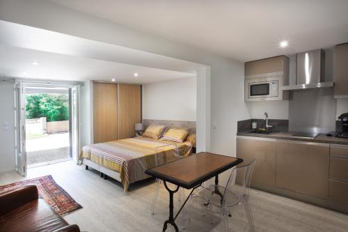 een slaapkamer met een bed en een tafel in een keuken bij LE PALMIER in Coulounieix-Chamiers