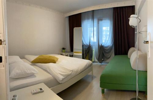 a bedroom with a bed and a green ottoman at Green Apartment 4 Mircea Voda in Bucharest