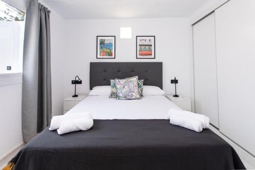 Un dormitorio con una gran cama blanca con dos almohadas. en New 3BR with great terrace By CanariasGetaway, en San Bartolomé