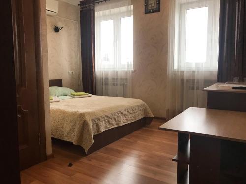 a bedroom with a bed and a desk at Hotel Garmonia in Pskov