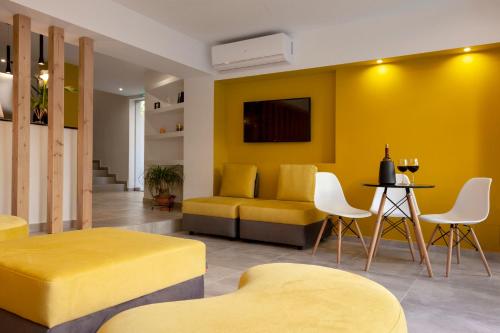 STAY INN في أثينا: غرفة معيشة صفراء مع أريكة وكراسي