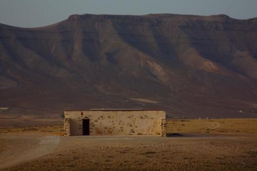 安地卡的住宿－Casa rural La Montañeta Alta，沙漠中的一座建筑,背景是一座山