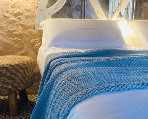a bed with a blue and white blanket on it at Casa Rural La Montañeta Alta in Antigua