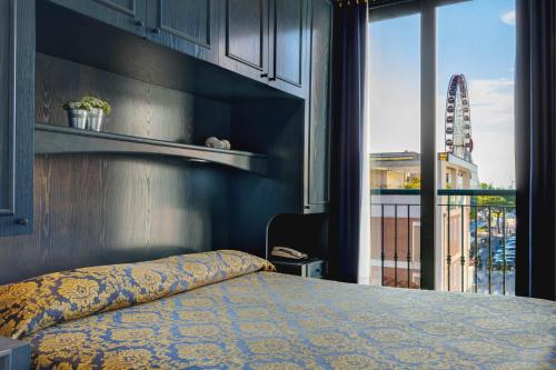 a bedroom with a bed and a large window at Hotel Garni San Carlo in Lido di Jesolo