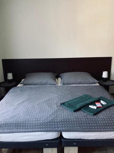 a bed with two green towels and two pillows at Pension Boulevard in Waldsassen