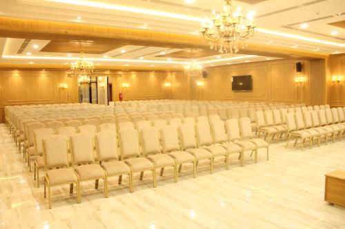 a banquet hall with rows of chairs and a screen at HOTEL PALAIS ROYAL in Sfax