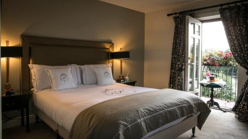 a bedroom with a large bed and a large window at Keenans Boutique Hotel in Termonbarry