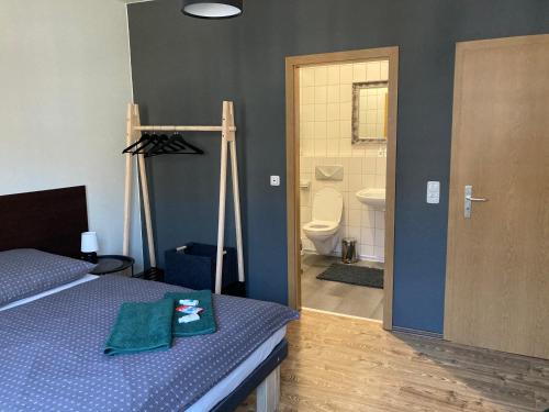 a bedroom with a bed and a bathroom with a toilet at Caffe Boulevard Penzion in Waldsassen