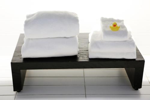 duas pilhas de toalhas e um pato de borracha numa mesa em Apartement 24, Hotell em Estocolmo
