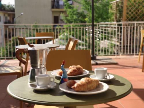 a table with two plates of pastries and coffee cups at Relais Villa Montedonzelli in Naples