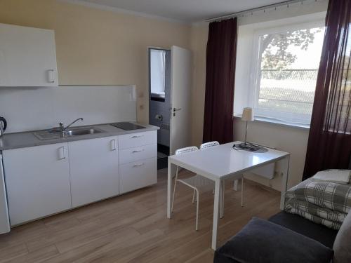 a kitchen with a sink and a table in a room at Ośrodek Wypoczynkowy SUM in Bialokosz
