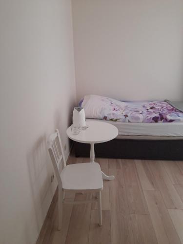 a small table and chair in a room with a bed at Ośrodek Wypoczynkowy SUM in Bialokosz