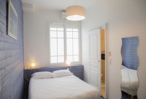 a small bedroom with a bed and a window at La Pergola d'Arcachon in Arcachon