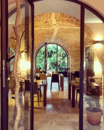 a dining room with an archway and a table and chairs at Le Mas de l'Espérance - Chambres d'hôtes de Prestige in Garons