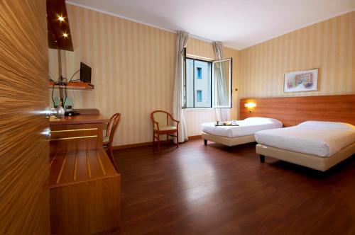 a hotel room with a bed and a table at Hotel 2C in Legnano