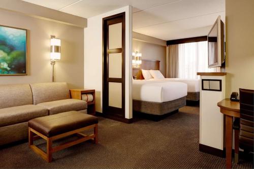 a hotel room with a bed and a couch at Tulsa South Medical Hotel & Suites in Tulsa