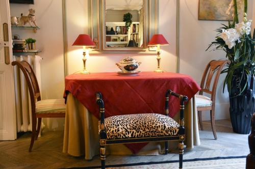 une table avec un chiffon de table rouge et deux lampes dans l'établissement Alma-Eiffel Tower, à Paris
