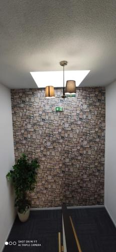 a ceiling with two lights and a brick wall at Glisy Hôtel in Glisy