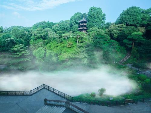 an aerial view of a misty hill with a pagoda at Hotel Chinzanso Tokyo in Tokyo