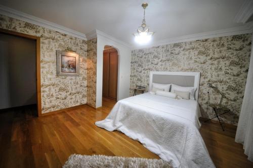 - une chambre avec un lit blanc et un mur en briques dans l'établissement Apartamento Rego da Balsa, à Carballo