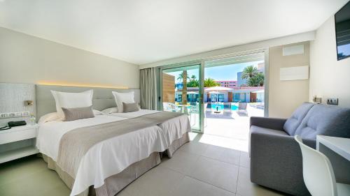 a bedroom with a bed and a couch and a patio at Sanom Beach Resort Only Adults in Playa del Ingles