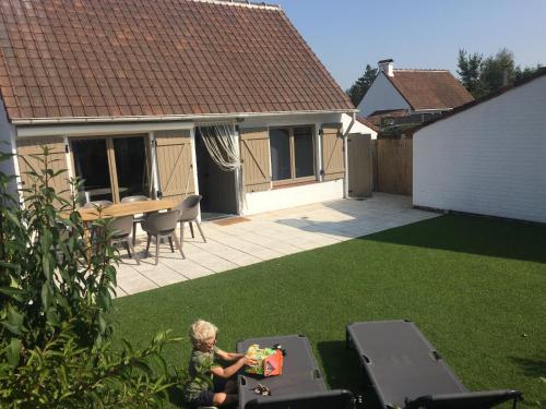 a child playing with a toy in a backyard at vakantiehuisje 007 in Koksijde