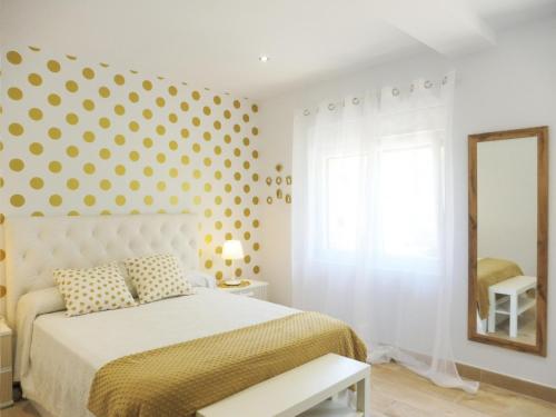 1 dormitorio con 1 cama con pared de lunares en El Corro, acogedora casa con jardín en el corazón de Cantabria, en Villasuso de Cieza