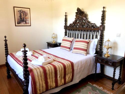 a bedroom with a large bed with a wooden headboard at Casa São Simão in Barcelos