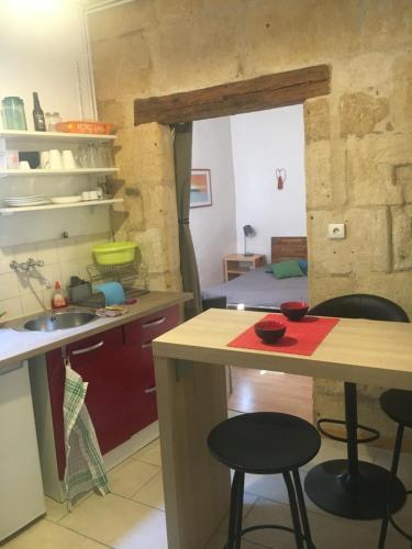 uma cozinha com um balcão e bancos num quarto em Appart sympa dans le vieux Nimes em Nîmes