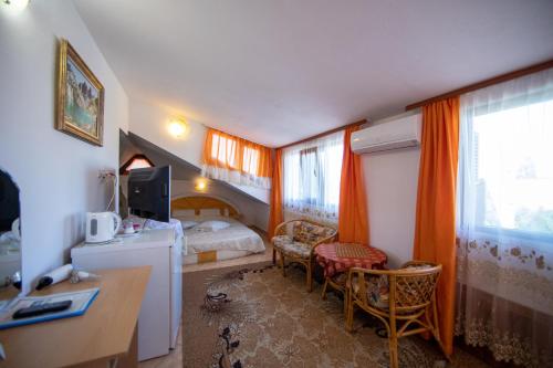 a bedroom with a bed and a desk with a computer at Guesthouse Elizabeth in Samokov
