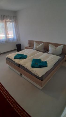 a large bed with two blue pillows on it at Haus am Zemminsee in Groß Köris
