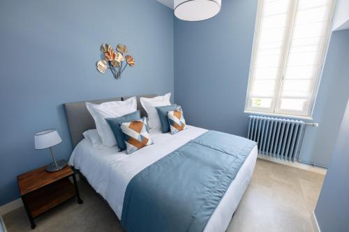 a blue bedroom with a large bed with blue walls at Le Rempart du Midi in Angoulême