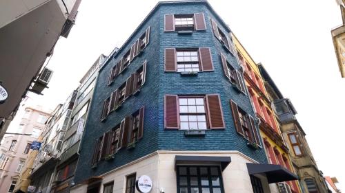 a tall blue building with windows on a street at Hostel Le Banc in Istanbul