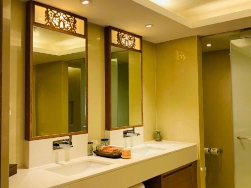 a bathroom with two sinks and two mirrors at Tanjung Rhu Resort in Tanjung Rhu 