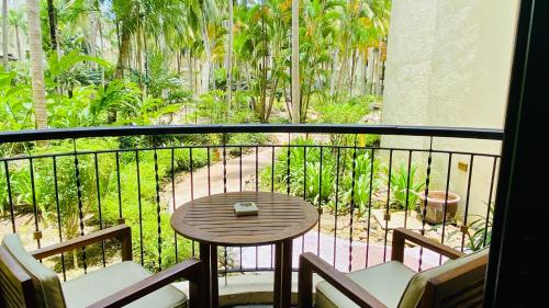 a balcony with a table and chairs and a view of a garden at Tanjung Rhu Resort in Tanjung Rhu