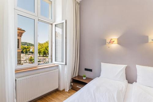 a white bedroom with a bed and a window at Palazzo Brașov in Braşov